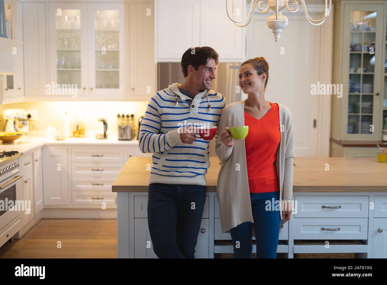 Happy young couple standing in the kitchen Stock Photo