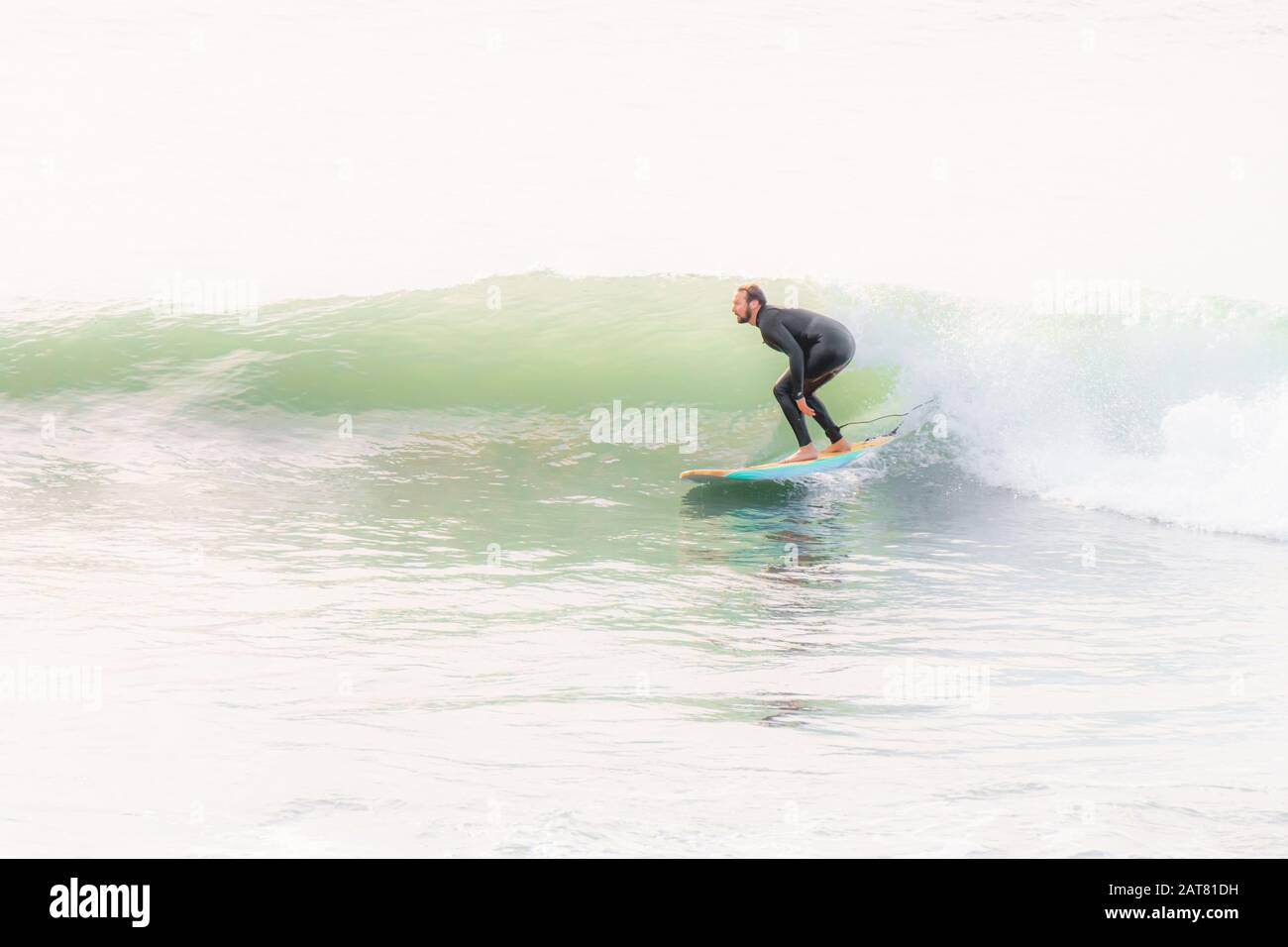 Surfer catching a wave at Porthleven, Cornwall, October 2019 Stock Photo