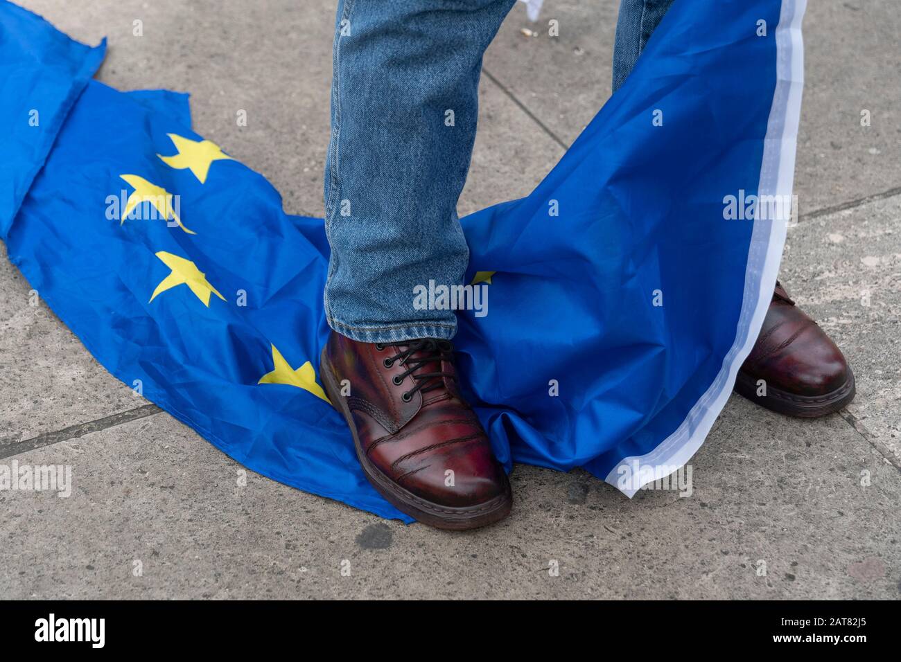London, UK 31 January 2020. A Pro-Brexit campaigner standing on a European Union Flag at Parliament Square on the day Britain officially leaves the EU Stock Photo
