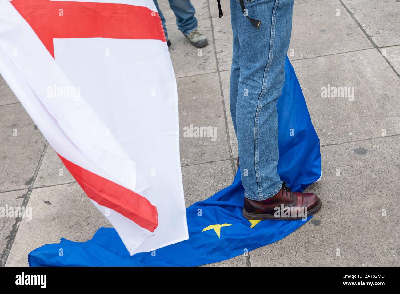 London, UK 31 January 2020. A Pro-Brexit campaigner standing on a European Union Flag at Parliament Square on the day Britain officially leaves the EU Stock Photo