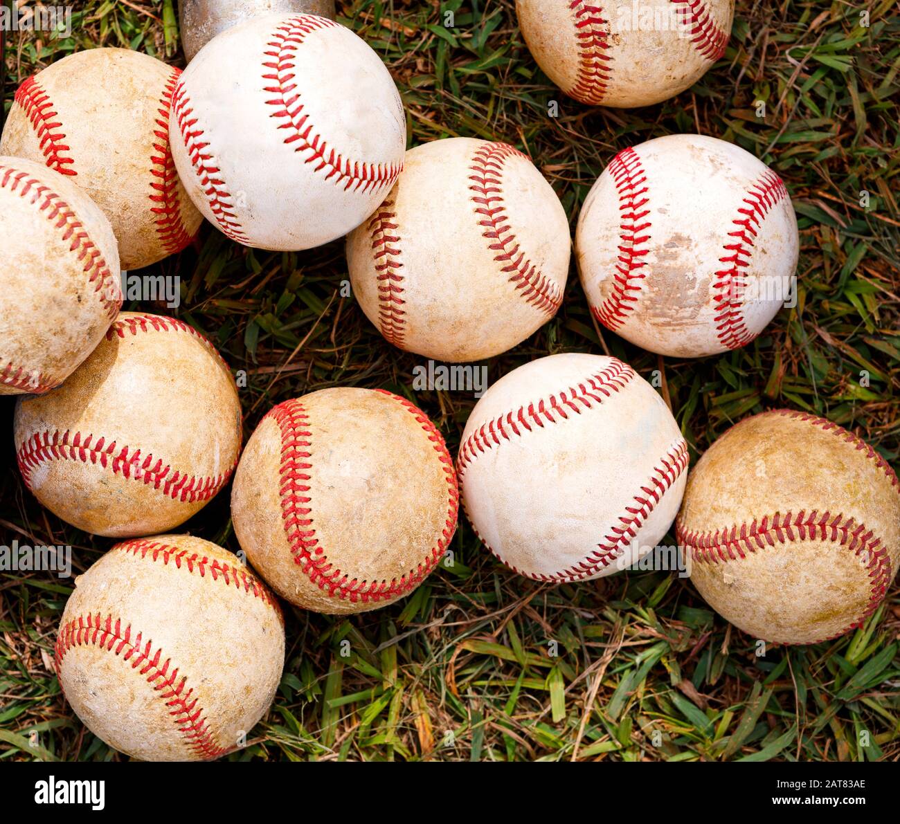 Used baseballs on the grass near the playing field Stock Photo