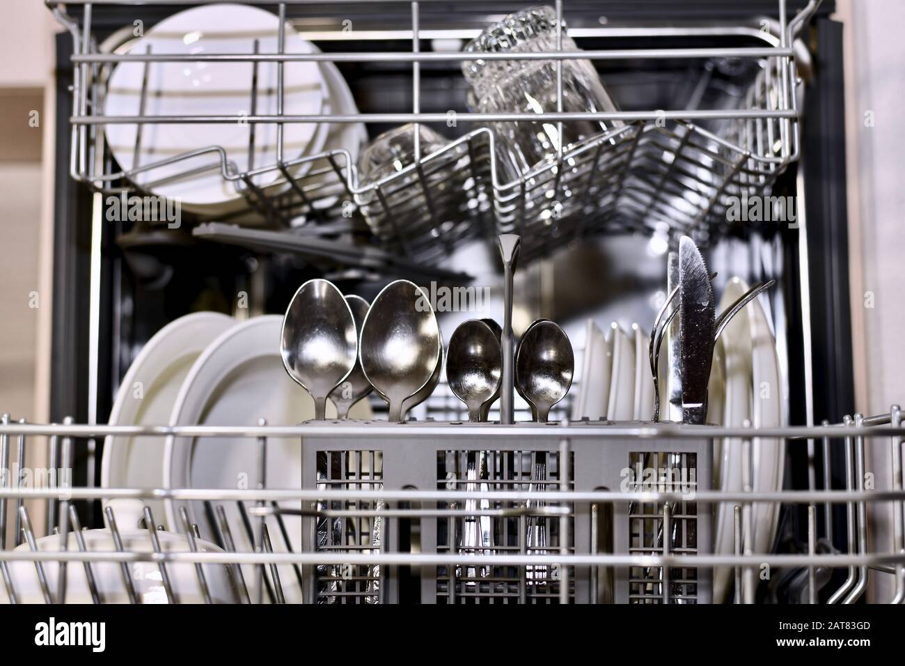The dishes are clean in an open dishwasher large with a focus on