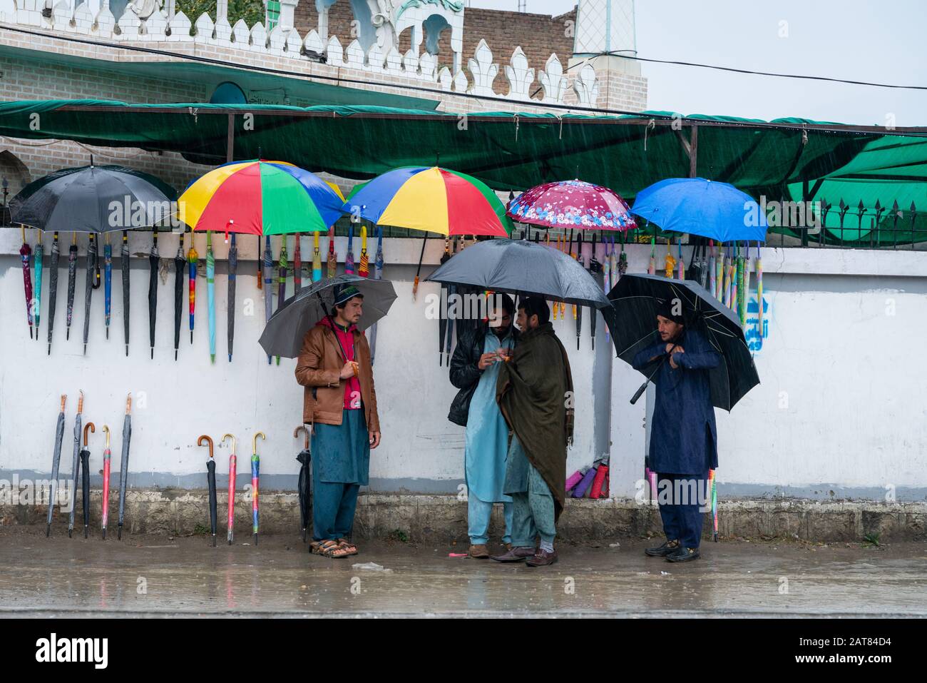 January 29, 2020 - KPK, Pakistan: Local residents purchasing umbrella from a street umbrella seller during rainy weather Stock Photo