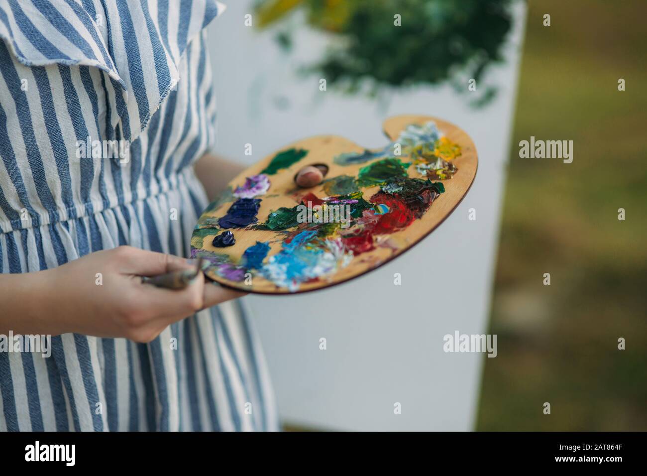 Girl is holding Palette with paints and spatula Stock Photo - Alamy
