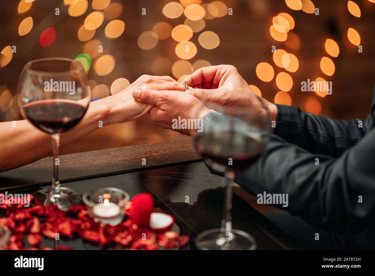 A couple having a romantic dinner and a suprise proposal in a elegance restaurant with beautiful decoration. Romance and Valentines day concept Stock Photo