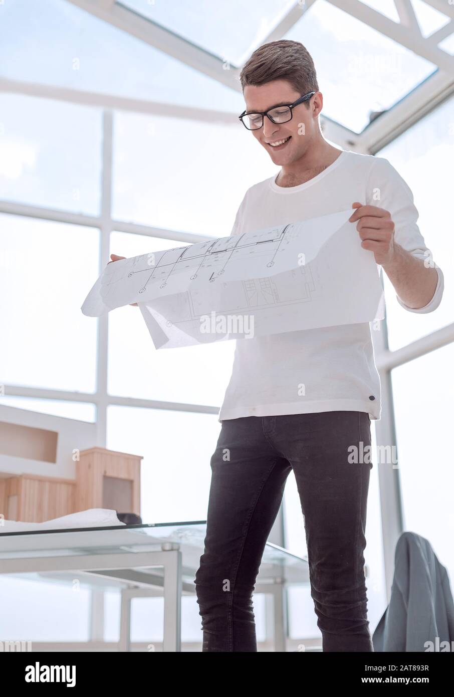 smiling young architect with a drawing of a new project. Stock Photo