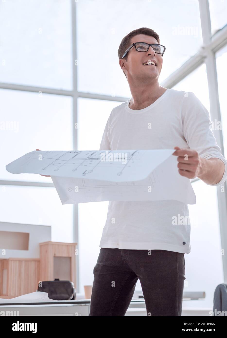 smiling young architect with a drawing of a new project. Stock Photo