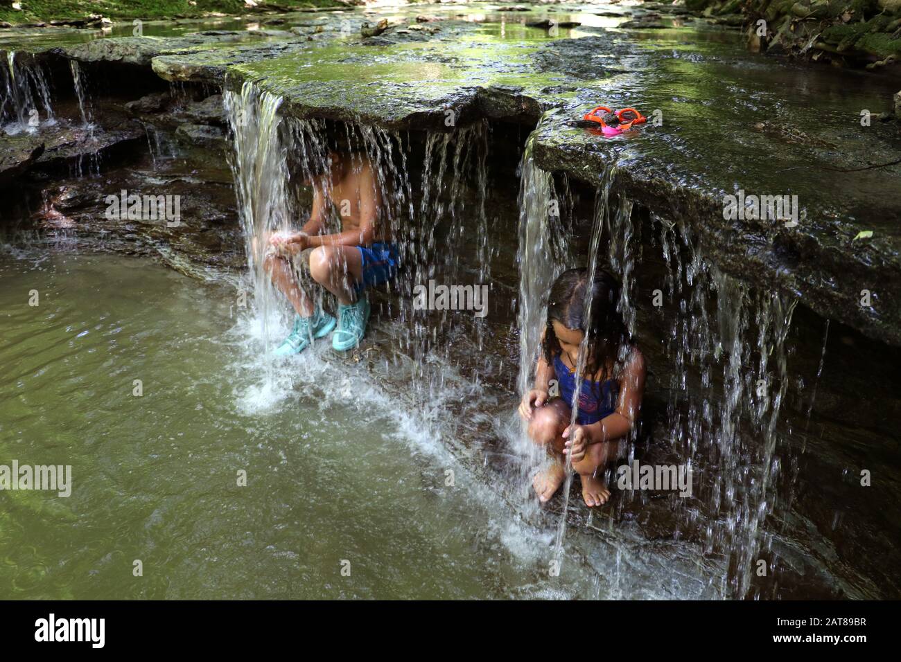 Family kids playing in creek waterfall Ohio USA Stock Photo