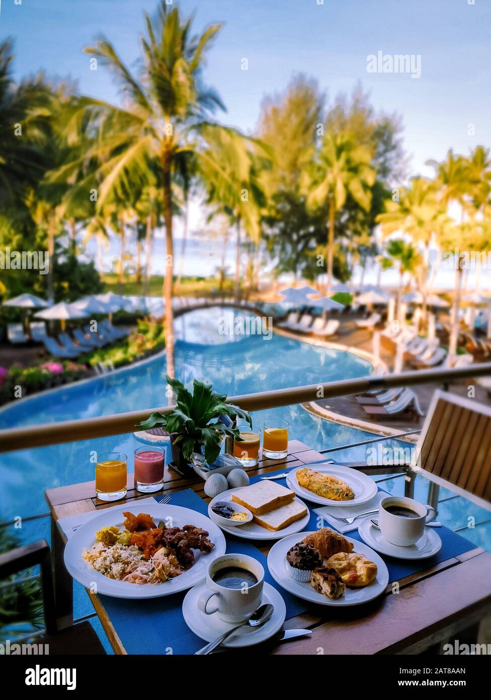 luxury hotel with breakfast table and a look at the swimming pool and