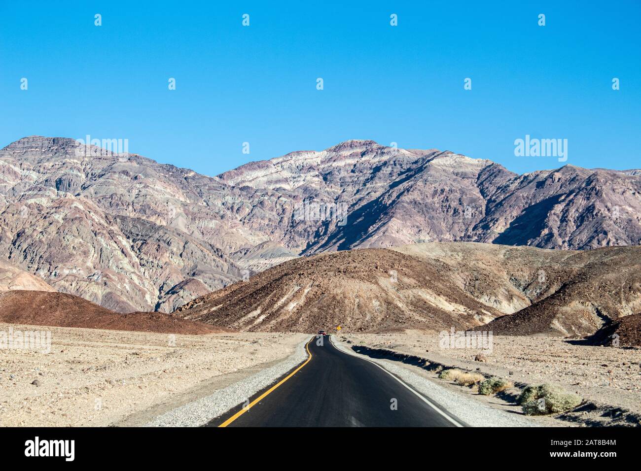 Shot of a road near the massive mountains in Death Valley National Park, California USA Stock