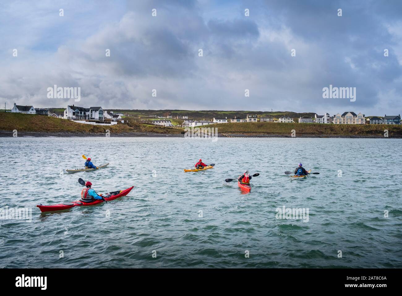 Canoeists in the bay at  Portballintrae a small seaside village in County Antrim, Northern Ireland Stock Photo