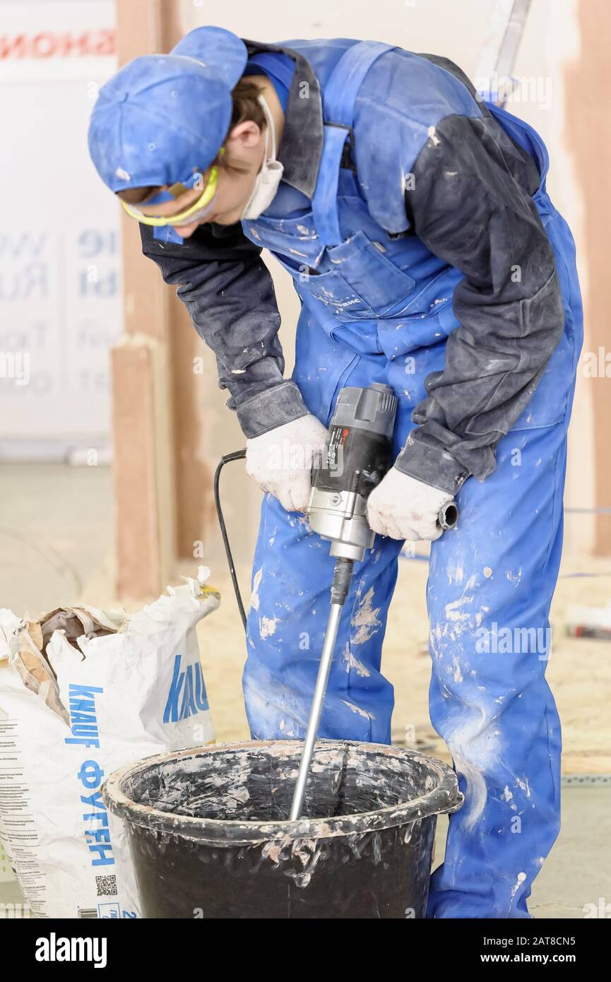 Worker mixing plaster with a drill in a bucket Stock Photo Alamy