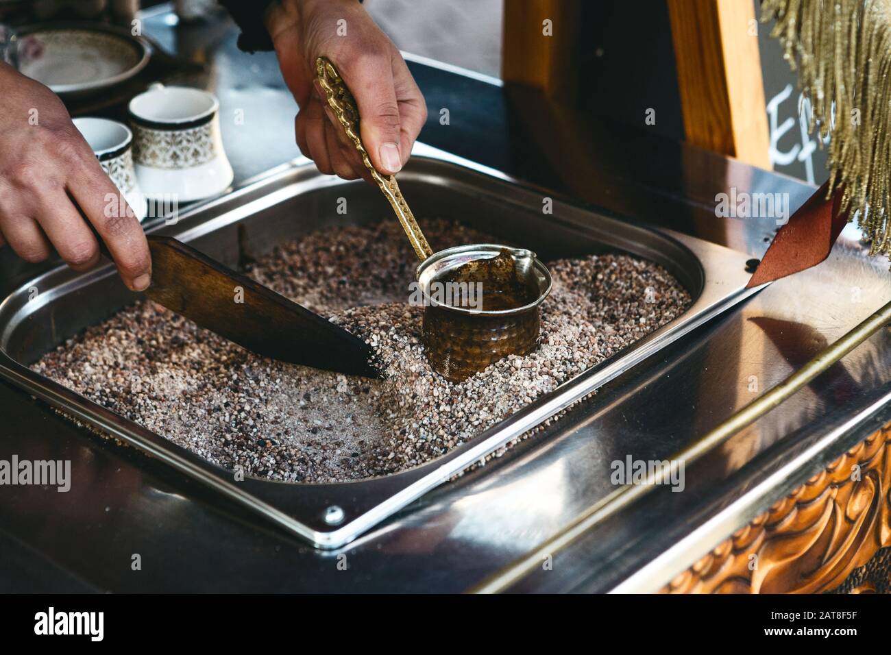 Making traditional black Turkish coffee or espresso in the sand in a special Turk. Stock Photo