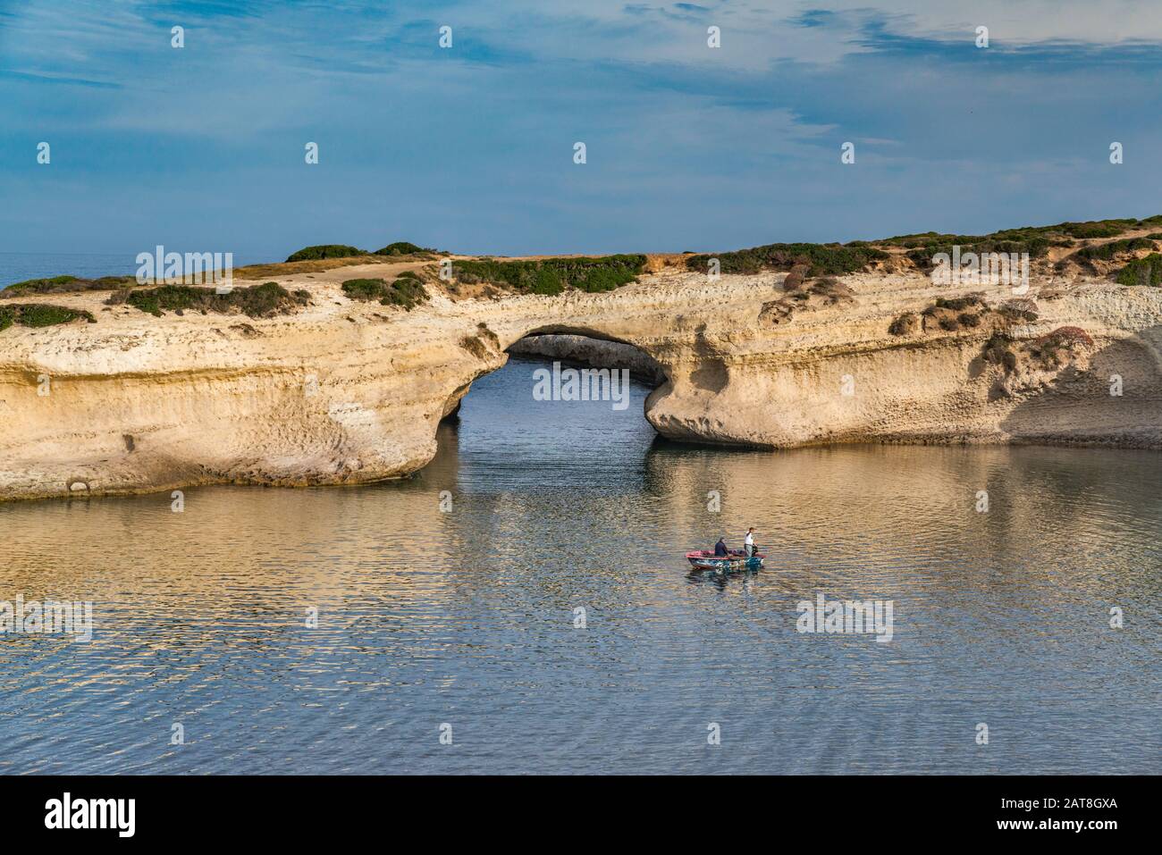 Men fishing at Arco di S'Archittu, natural arch near Spiaggia dell'Arco, beach in S'Archittu, municipality of Cuglieri, Sardinia, Italy Stock Photo