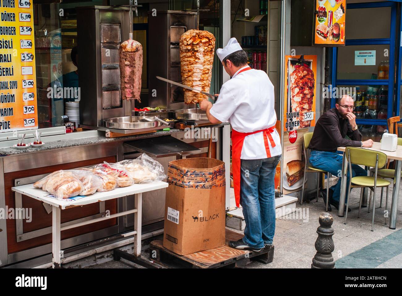 Istanbul, Turkey - June 8 2014: Cook Cutting Meat From a Doner Kebab for a Customer in a Turkish Street Food Restaurant. Stock Photo