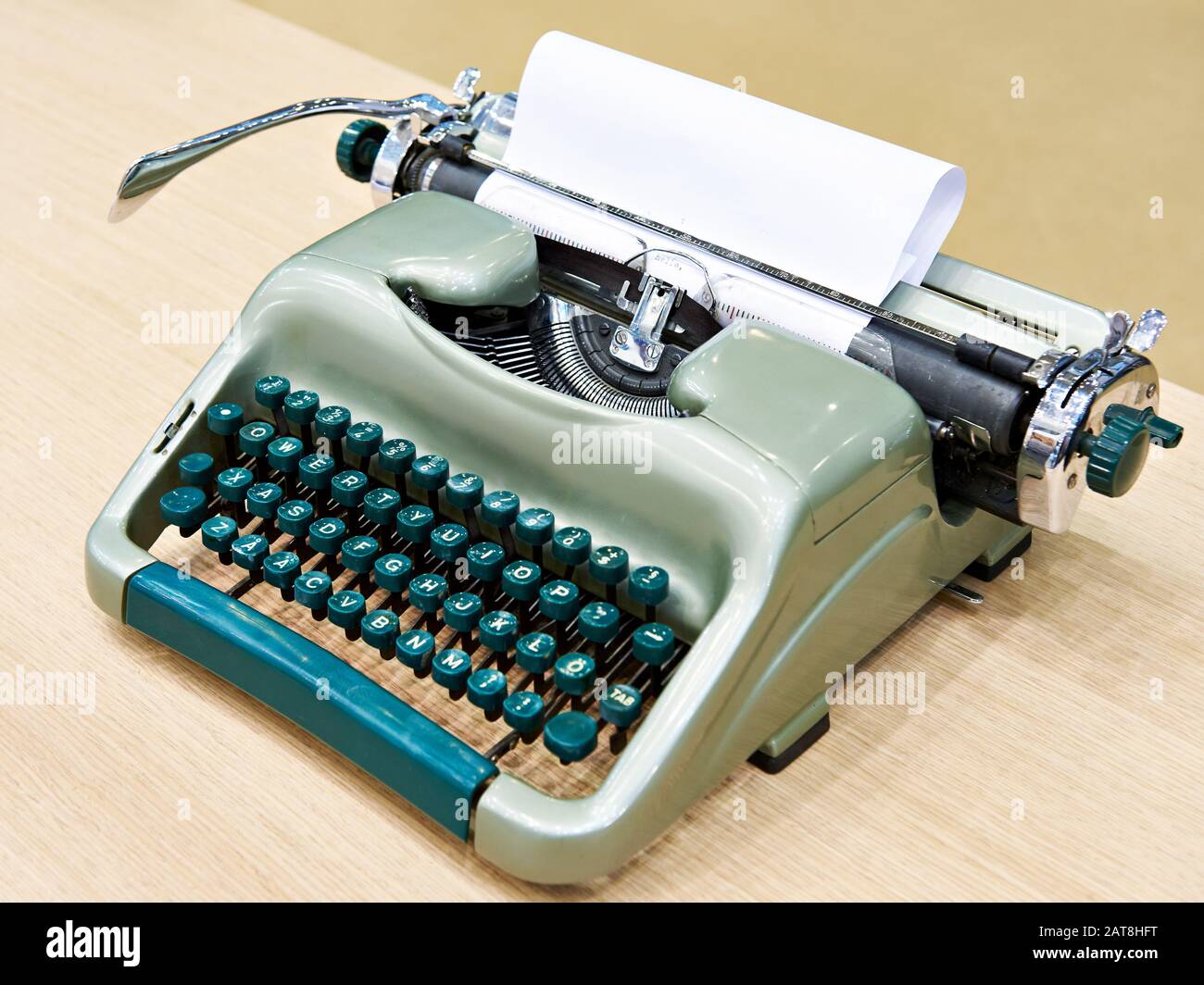Green retro typewriter on wooden table Stock Photo