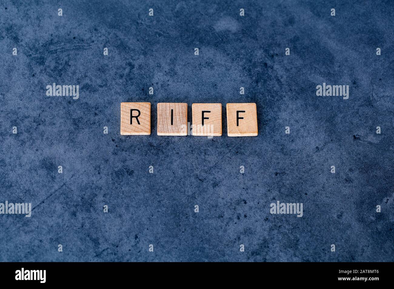 'RIFF' (Registered Retirement Income Fund) spelled out in wooden letter tiles on a dark rough background Stock Photo