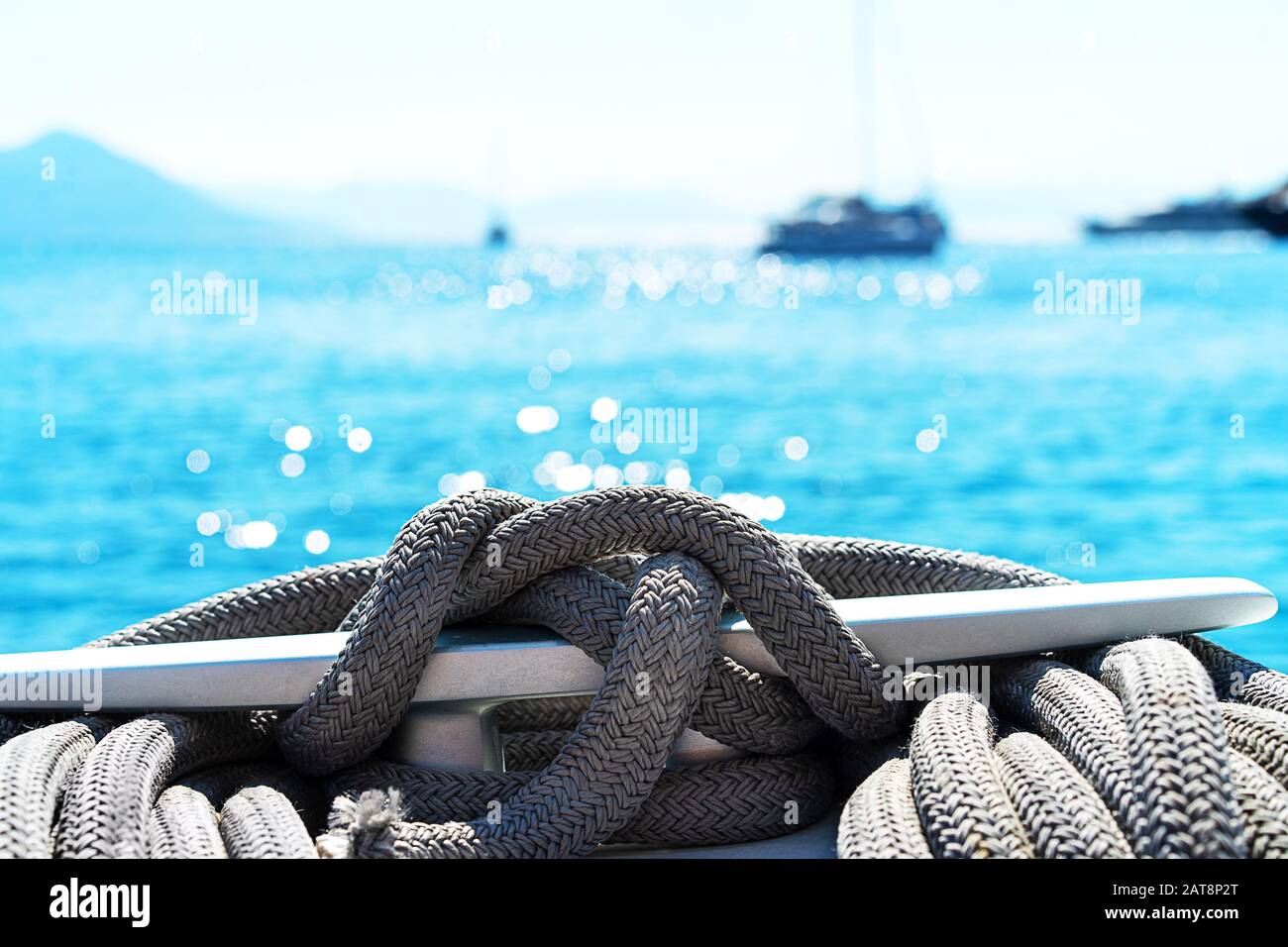 Yacht winch and cable on a sailing yacht. Rope wound on the small windlass of the yacht ship. Greece holiday. Stock Photo