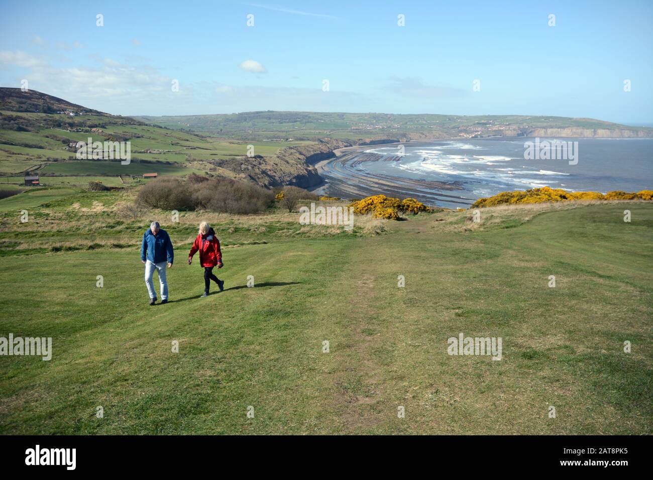 An older couple walking on the Cleveland Way above Robin Hood's Bay, North York Moors National Park, Yorkshire, England, United Kingdom. Stock Photo
