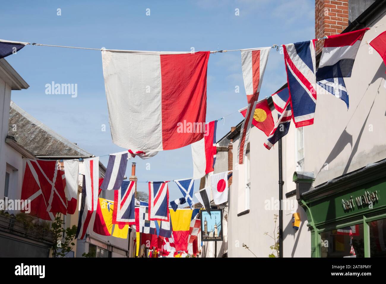 Traditional red and white flags hanging in street during the Obby Oss celebrations, Padstow, Cornwall, UK Stock Photo