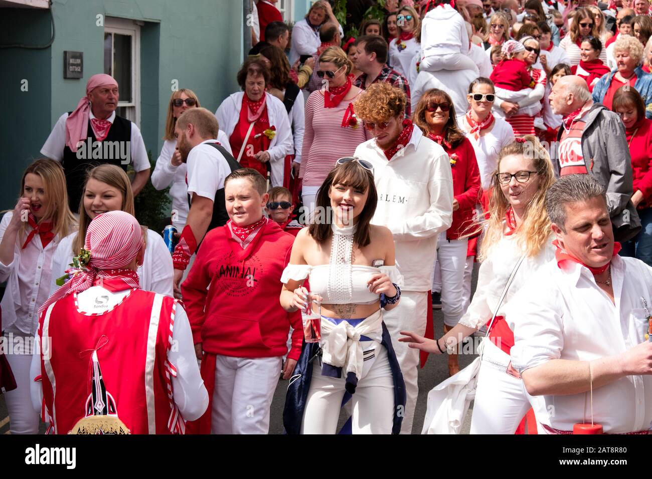 Crowds following the red ribbon Obby Oss procession, Padstow, Cornwall, UK Stock Photo