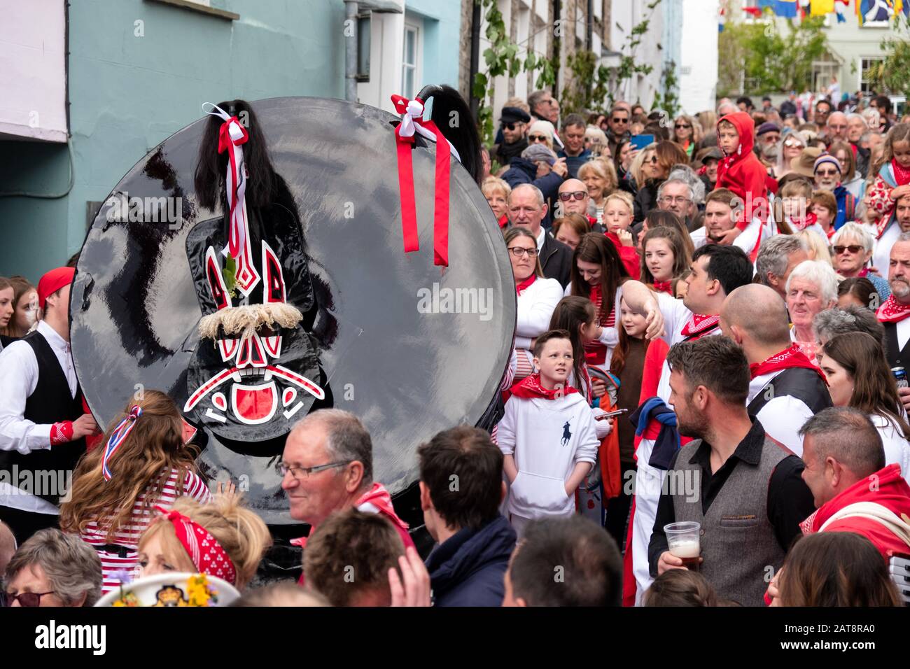 Crowds following the red ribbon Obby Oss procession, Padstow, Cornwall, UK Stock Photo