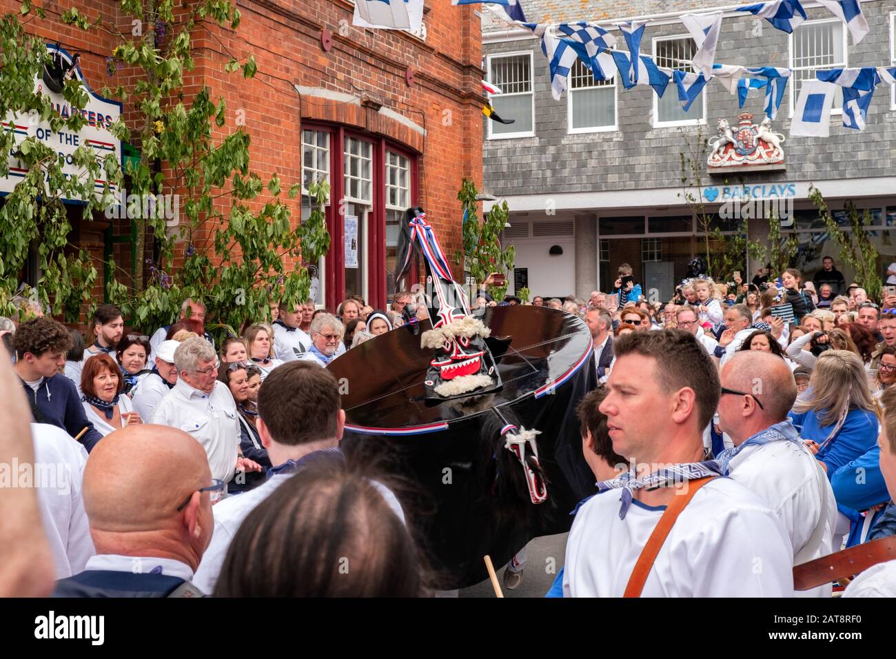 Crowds following the Obby Oss procession wearing blue ribbons, Padstow, Cornwall, UK Stock Photo