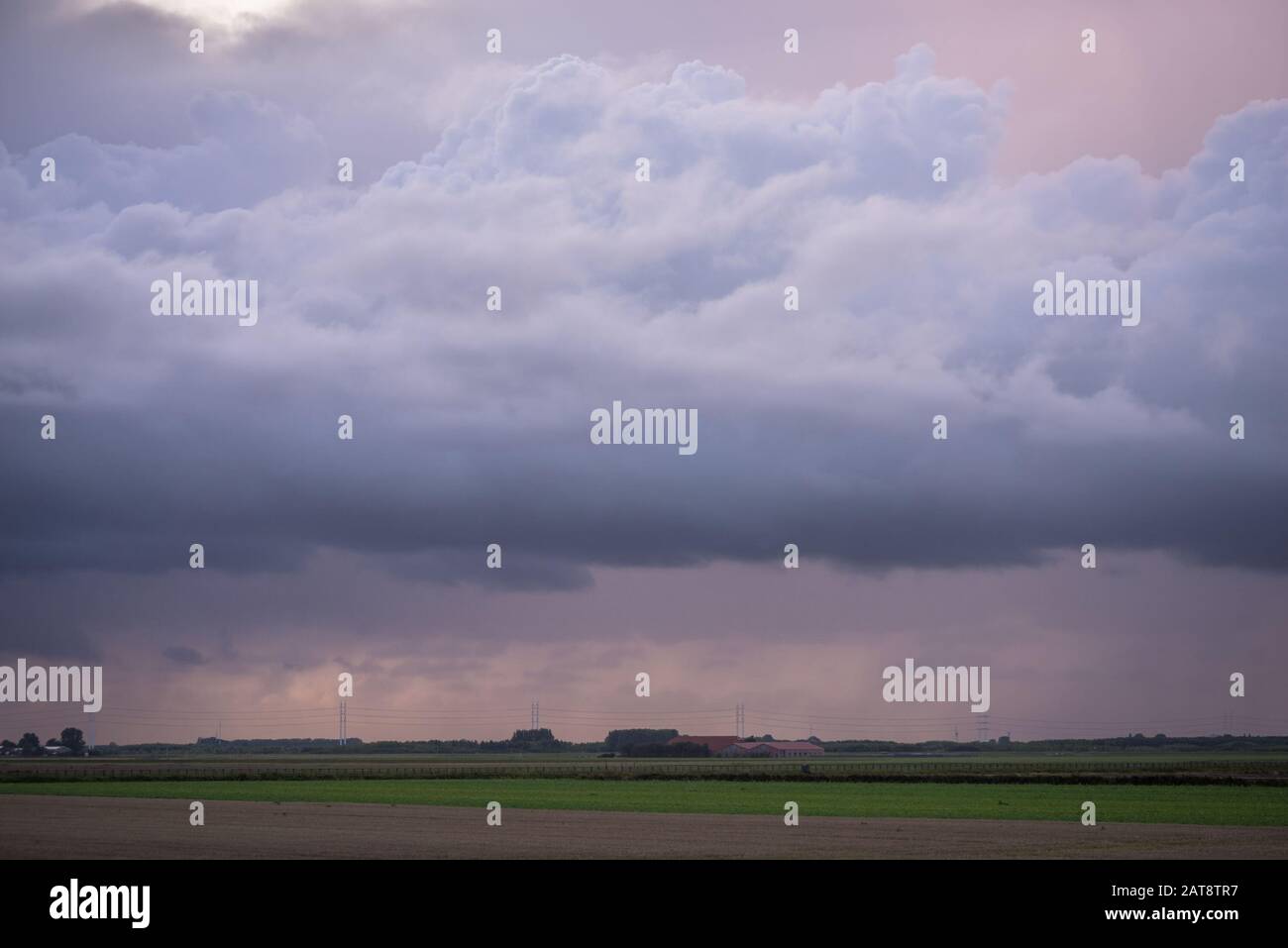Stormclouds and falling rain at sunset Stock Photo