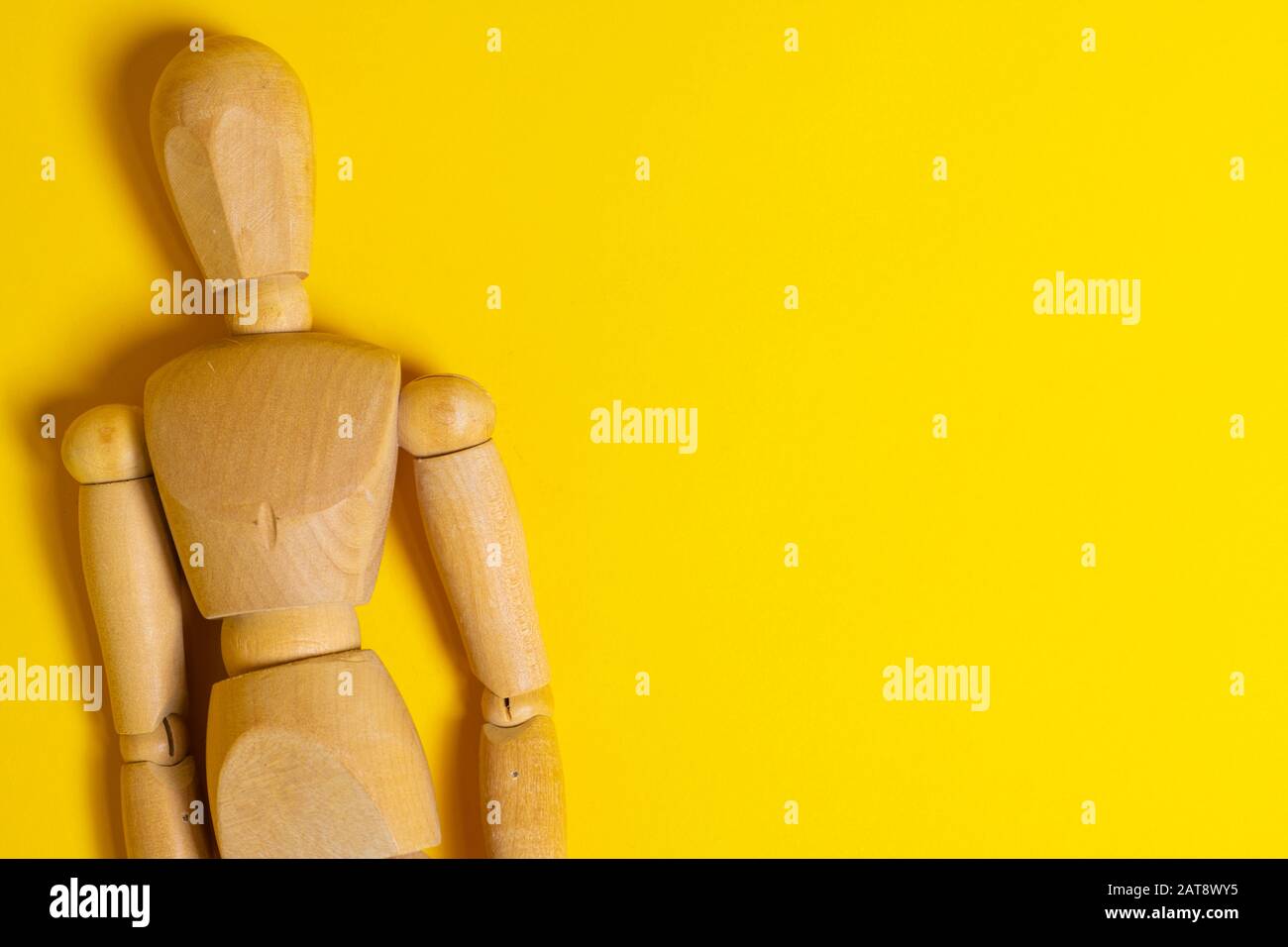 Wooden Human mannequin on a bright yellow background Stock Photo