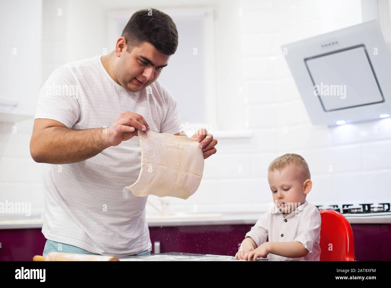Father tossing pizza dough. Happy family in kitchen Stock Photo Alamy
