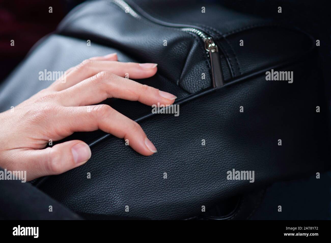 woman hand resting on a black purse Stock Photo