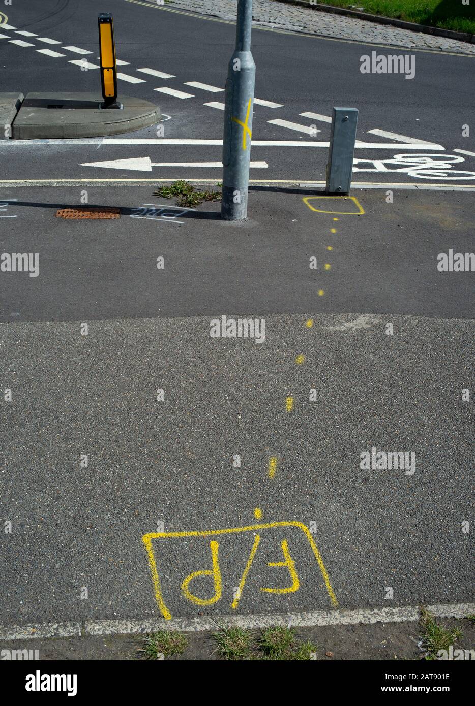 Various spray painted road markings on new junction marking out underground cables for new installed traffic signs and bollards. Stock Photo