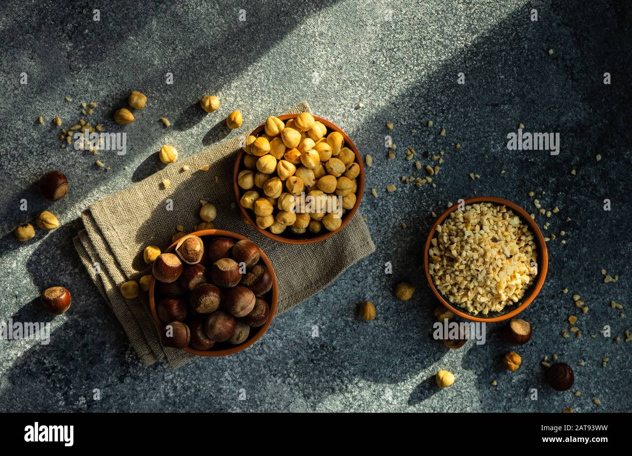 Different types of hazelnuts on dark wooden background with copyspace