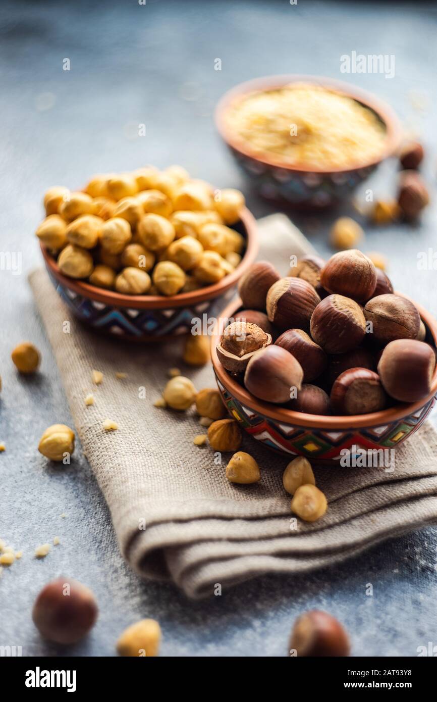 Different types of hazelnuts on dark wooden background with copyspace