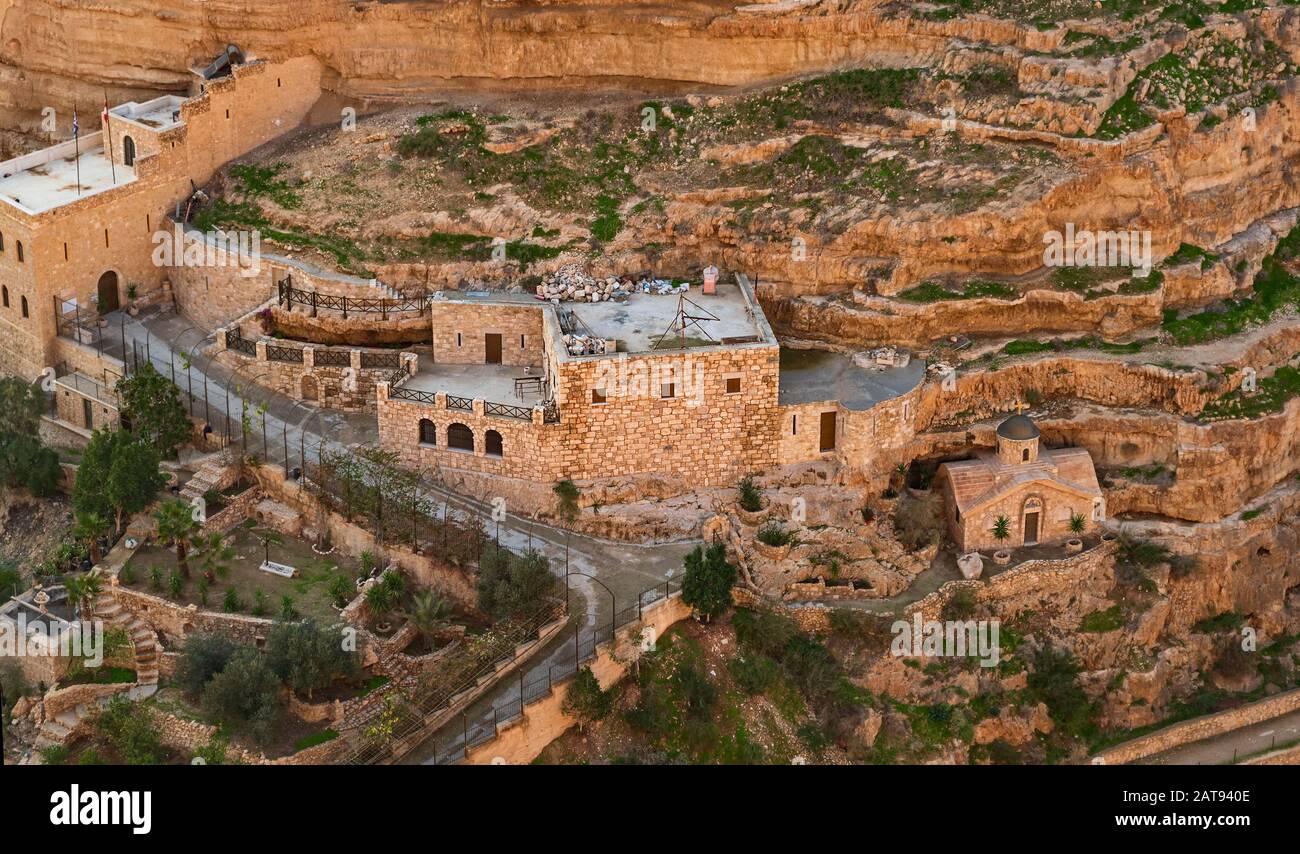 closeup of the east side of saint george's monastery and chapel in wadi qelt showing buildings carved into the limestone cliffs and caves of wadi qelt Stock Photo