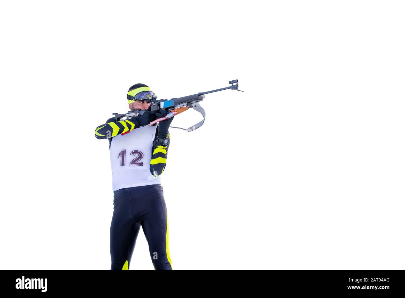 Isolated biathlete shoots with rifle in a standing position Stock Photo