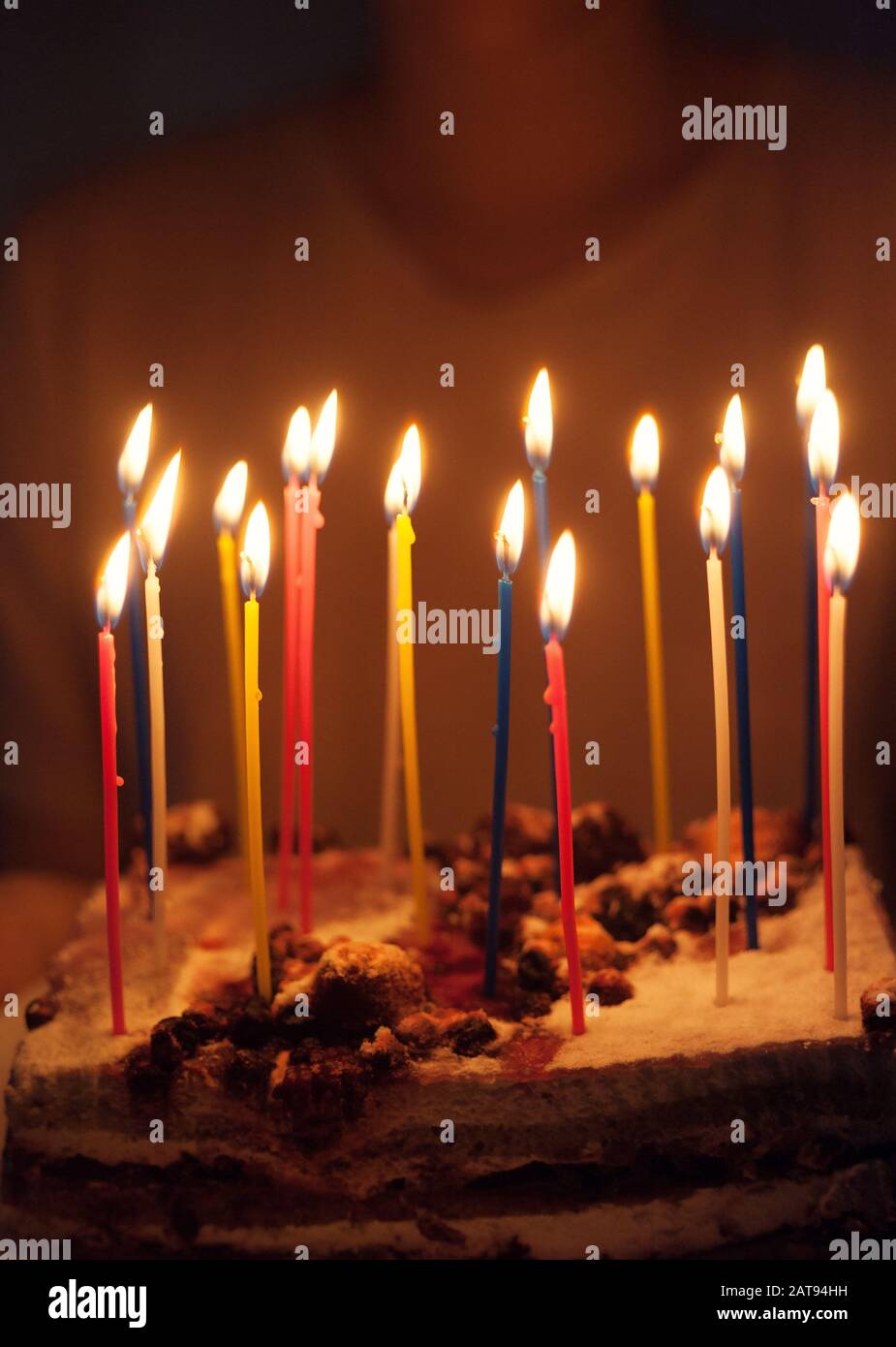 18 multi-colored candles on a cake in hands in the dark Stock Photo - Alamy