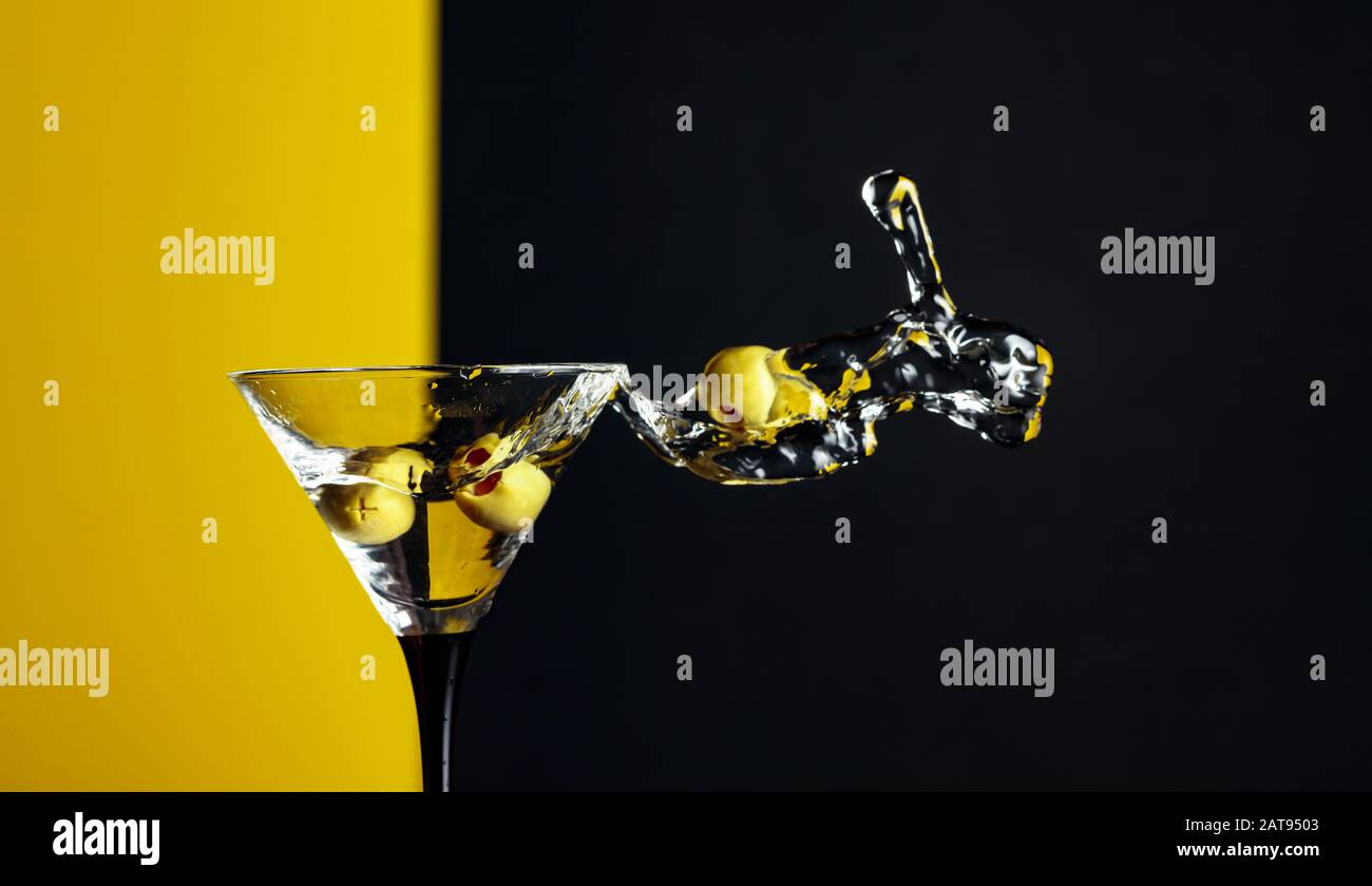 Martini with green olives splash. Copy space Stock Photo Alamy
