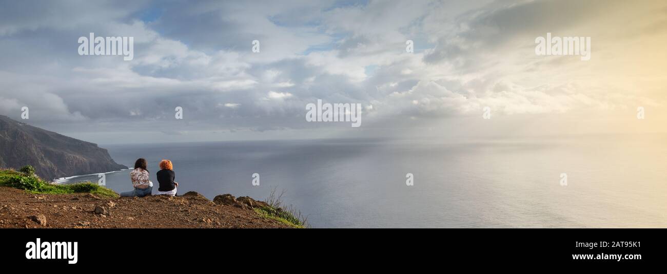 Girl sitting on edge cliff hi-res stock photography and images - Alamy