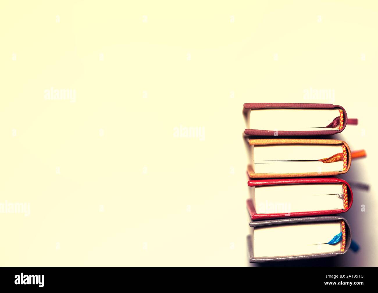 four small multi-colored books on a bright white background Stock Photo