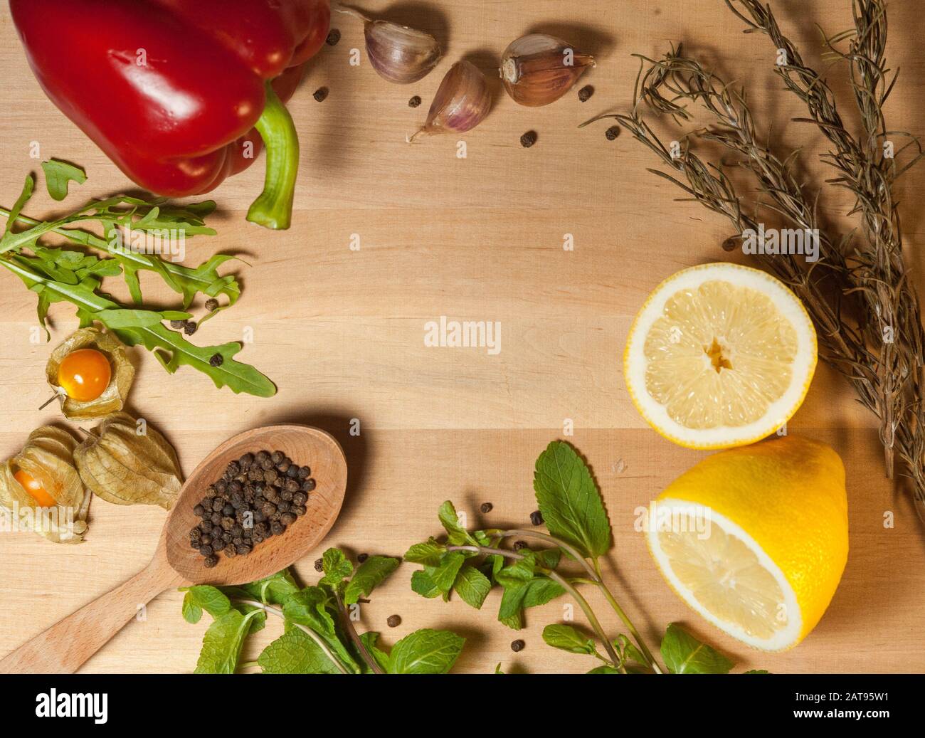 spices and vegetables on a wooden board with a wooden spoon Stock Photo