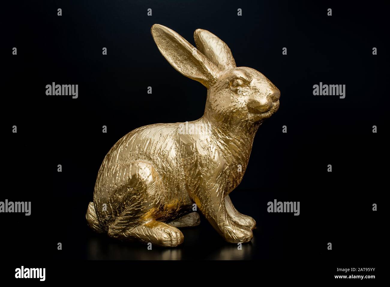 gold easter bunny rabbit on black background Stock Photo - Alamy