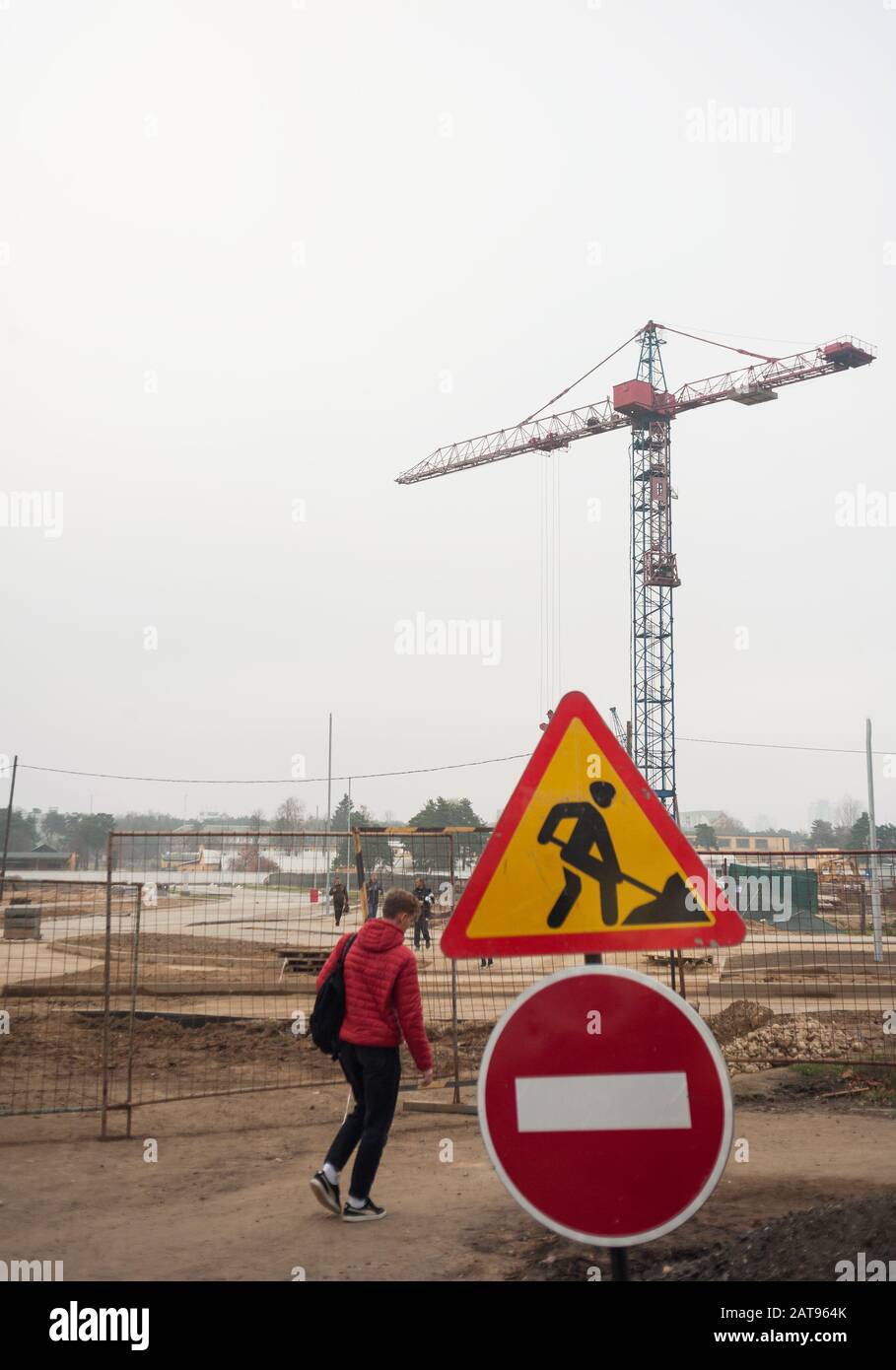 a person ignores traffic signs at a construction site prohibiting passage and passage Stock Photo