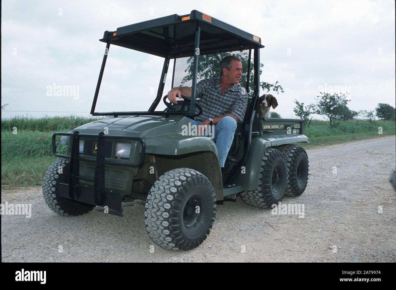 Crawford, Texas; Governor George W. Bush meets with the media at his ranch near Waco during a break from his presidential campaigning. He is driving his John Deere 6x4 Trail Gator Utility Vehicle. ©Bob Daemmrich Stock Photo