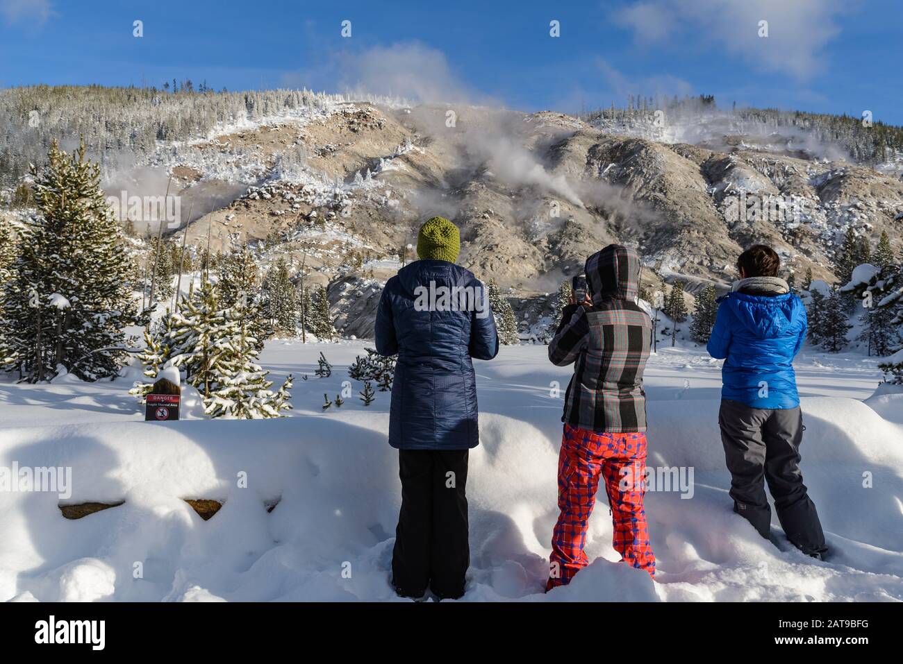Visitors taking photos of the fumarole at the Roaring Mountain in winter. Yellowstone National Park, Wyoming, USA Stock Photo