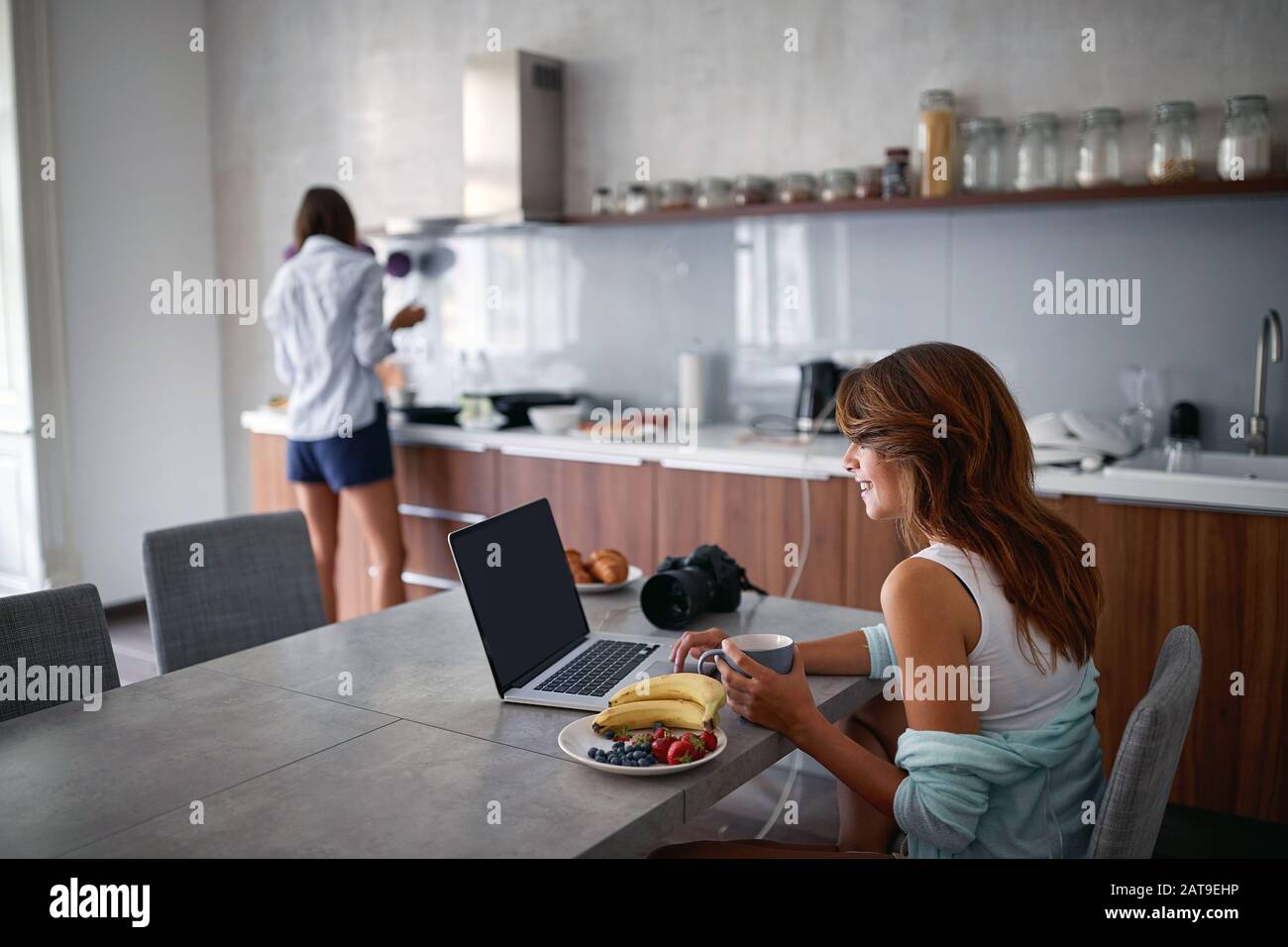 Young Woman  enjoying in  morning coffee while working on laptop. Stock Photo