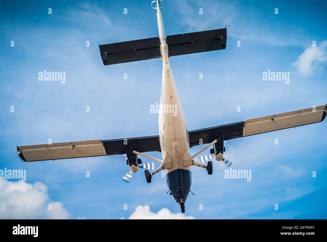 Twin Engine Turbo-Prop Plane Airborne - Flying, Air Travel and Vacation Concept in Blue and White, a Shoulder Wing Propeller Airplane Stock Photo