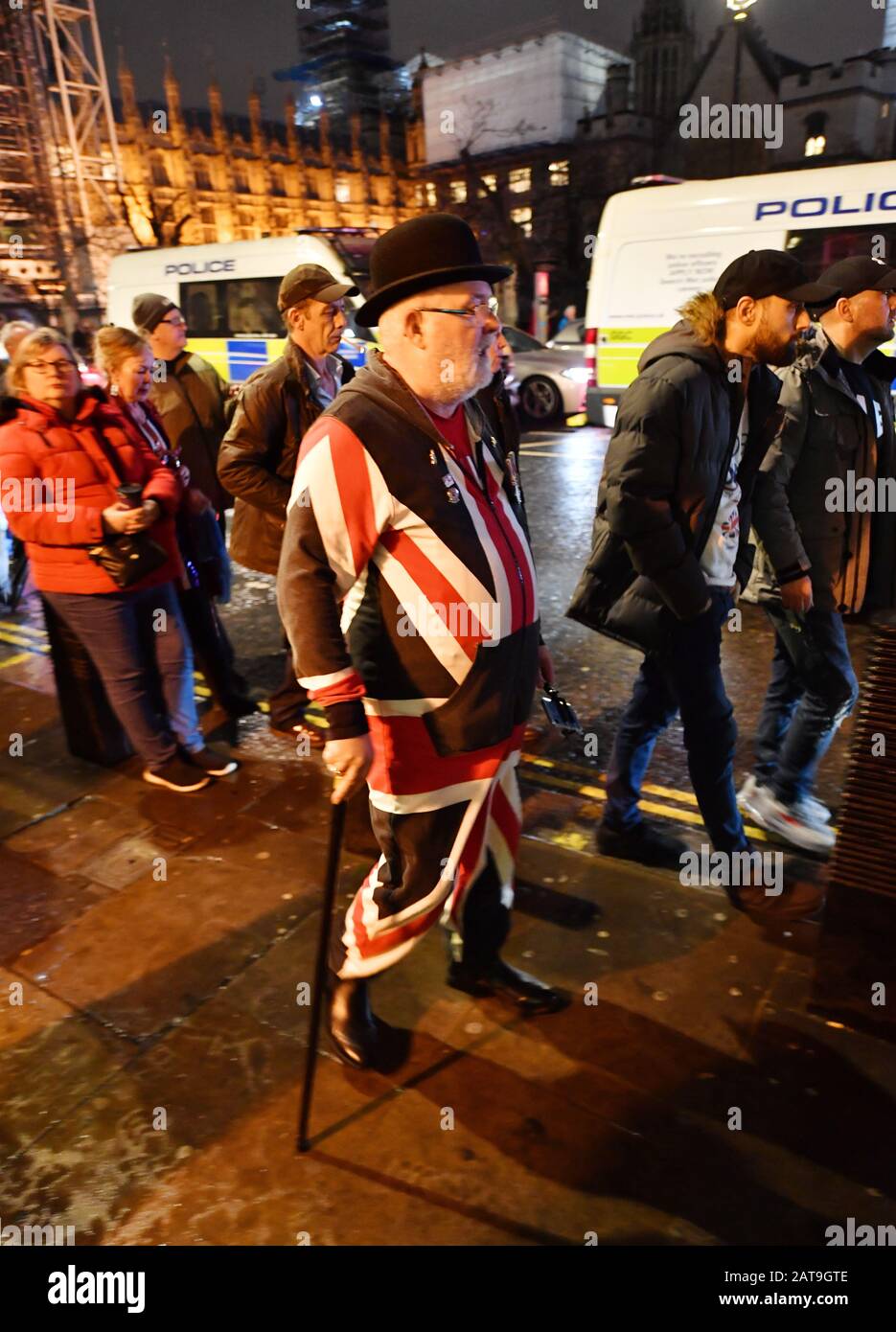 Parliament Square, London, UK. 31st January 2020. Union flag suited man wearing a bowler makes his way past police vans to the Leave Means Leave Brexit Celebration opposite the Houses of Parliament to mark the UK leaving the EU at 11.00pm. Credit: Malcolm Park/Alamy Live News. Stock Photo