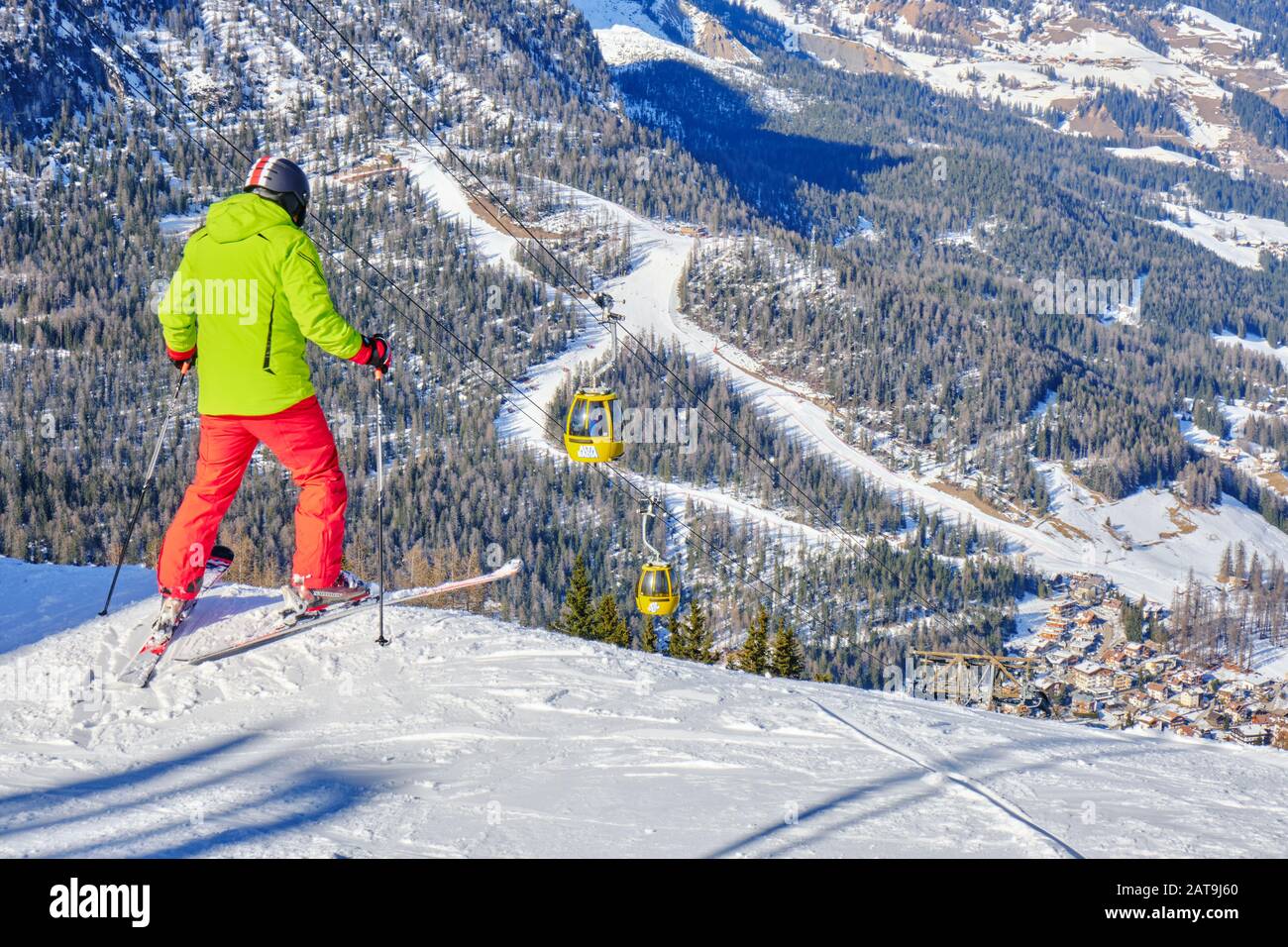 Alta Badia, Italy - January 21, 2020: Skier preparing to drop into a red ski run above La Villa village, South Tyrol, in Dolomites, Italy. Stock Photo