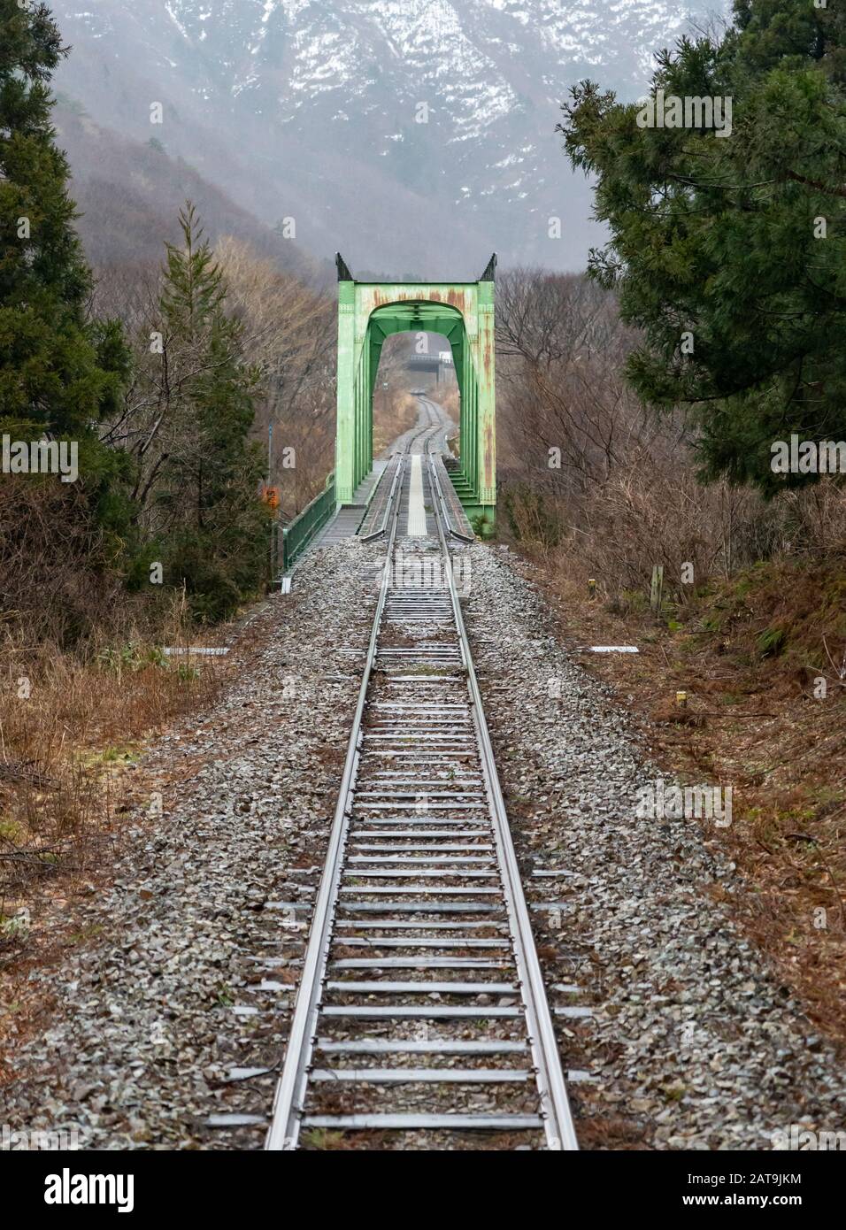 A bridge and tracks seen from a train on the JR East Yonesaka Line in Yamagata Prefecture, Japan. Stock Photo